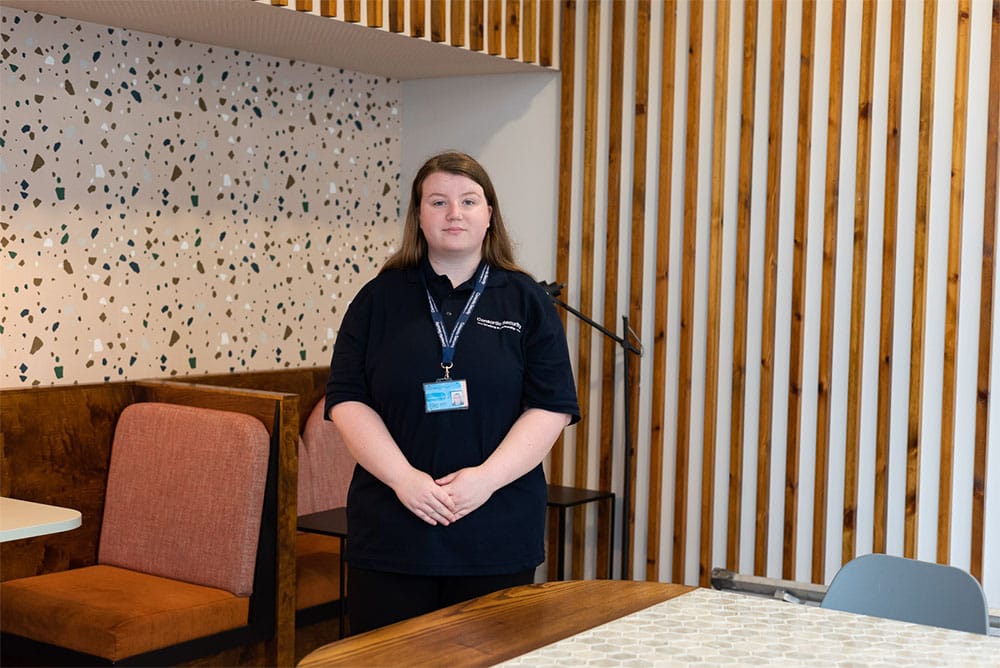 Woman standing by chairs